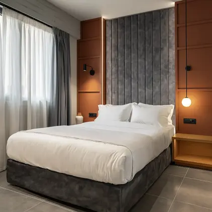 a bed with a lamp and a wall behind it