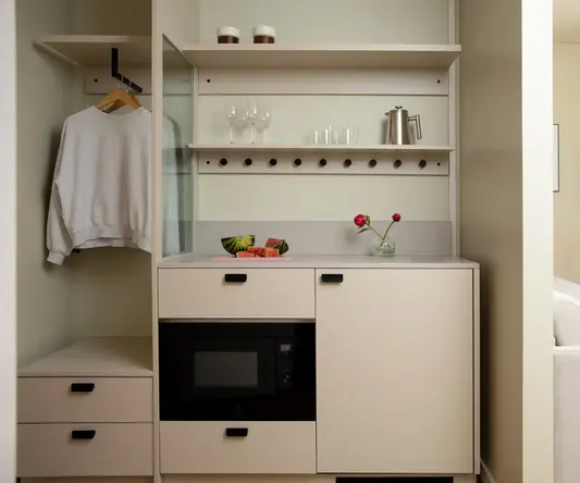 a kitchen with a microwave and wine glasses