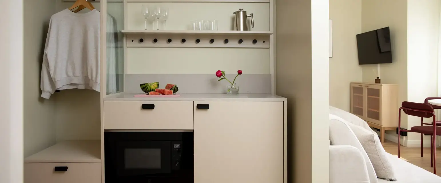 a kitchen with a microwave and wine glasses