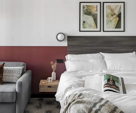 a bed with a book and a couch in a room