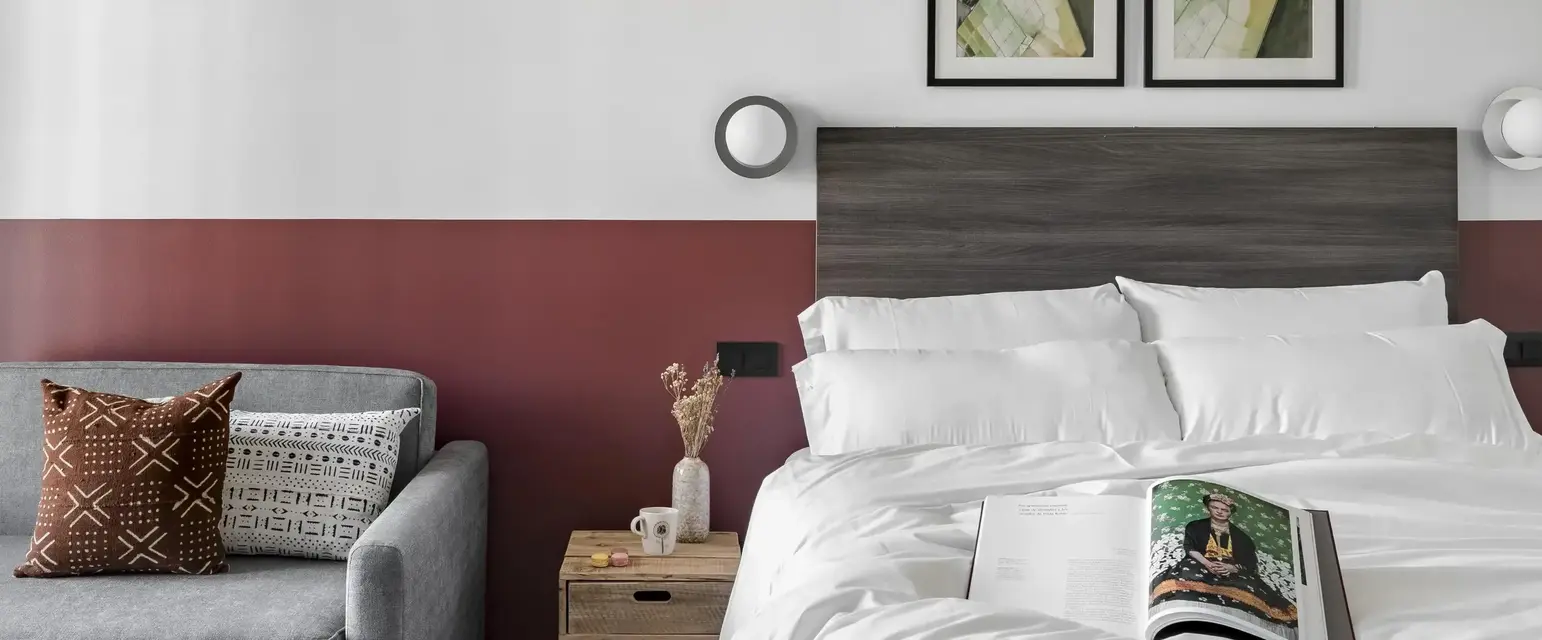 a bed with a book and a couch in a room