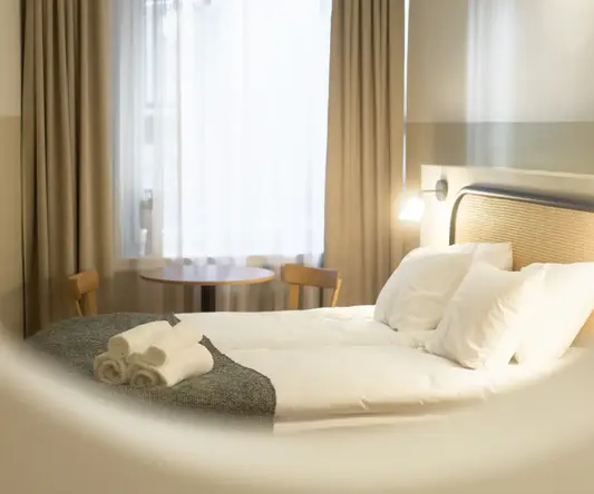 a bed with white sheets and towels on it