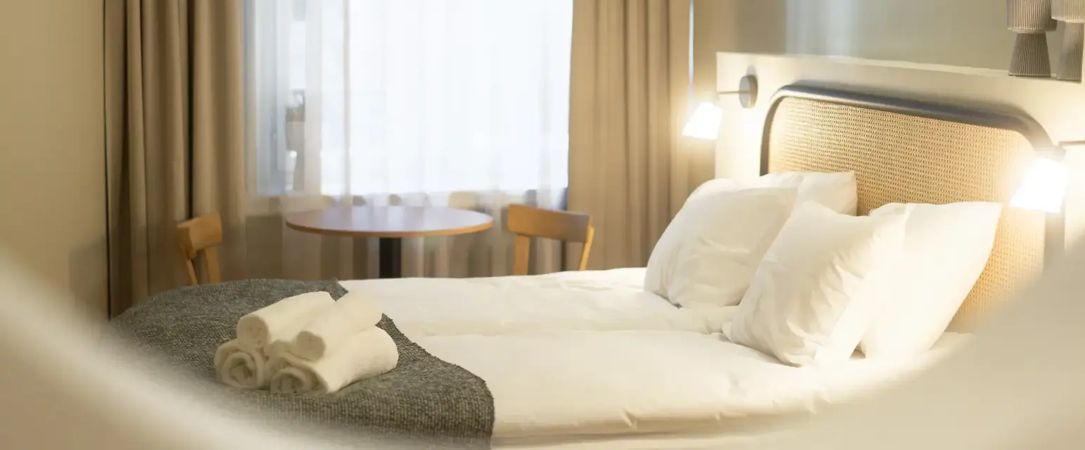 a bed with white sheets and towels on it