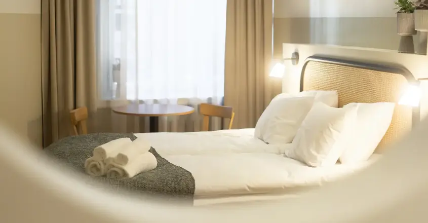 a bed with white sheets and towels on it