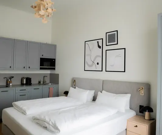 a bed with white sheets and pillows in a room