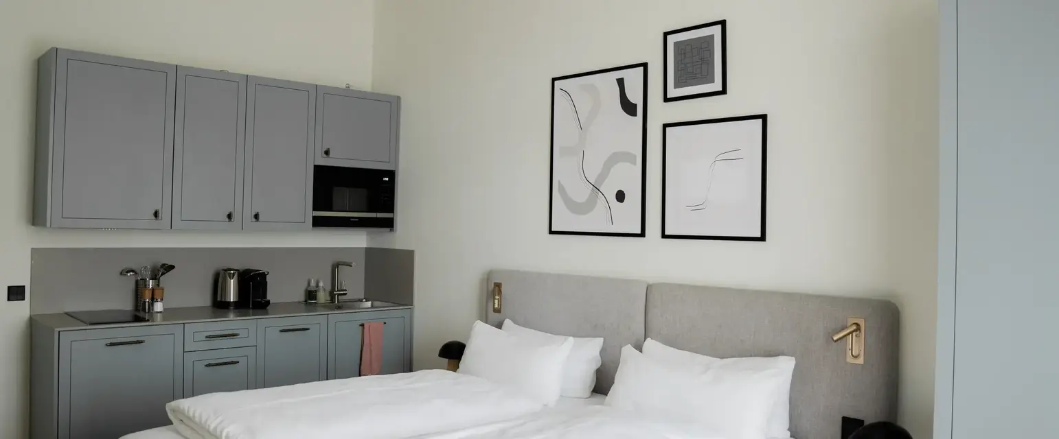 a bed with white sheets and pillows in a room