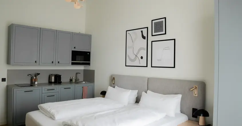 a bed with white sheets and pillows in a room