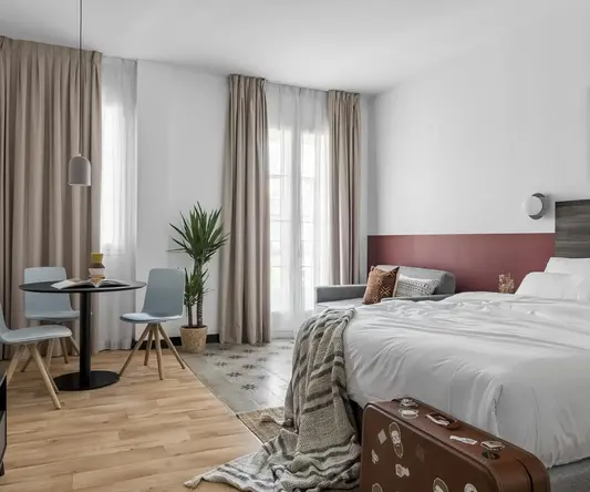 a room with a bed and a table and chairs