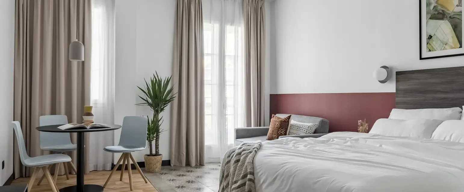 a room with a bed and a table and chairs