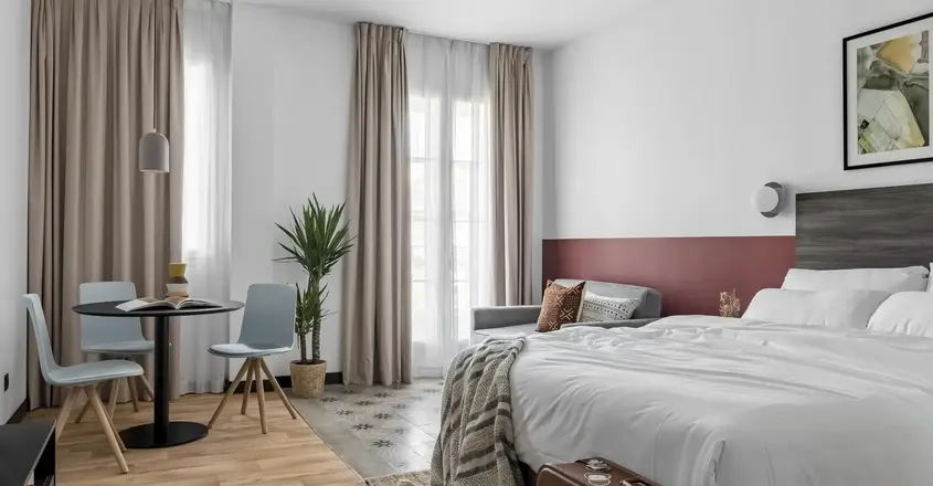 a room with a bed and a table and chairs