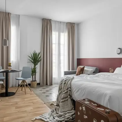 a room with a bed and a table and chairs