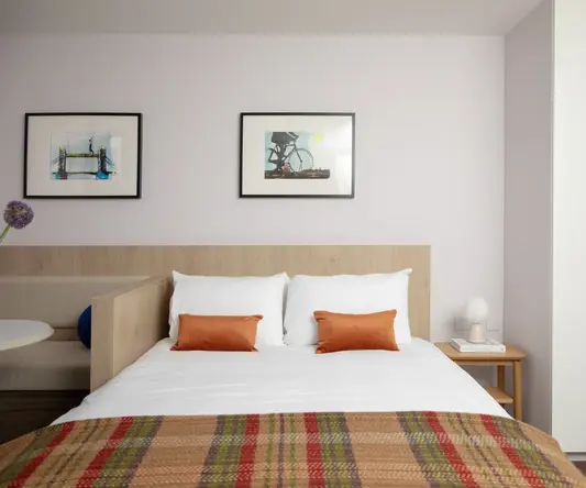 a bed with pillows and a picture on the wall