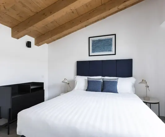 a bed with a blue headboard and a black shelf