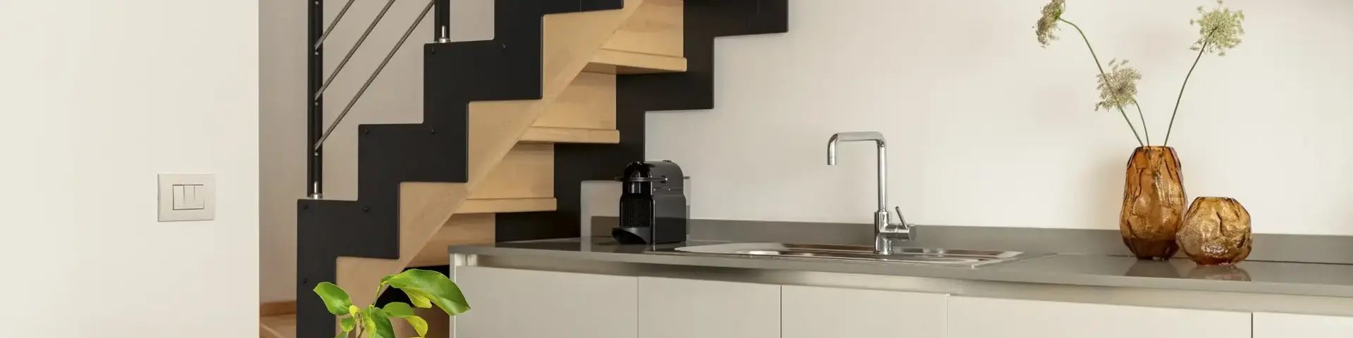 a kitchen with a staircase and a table with lemons