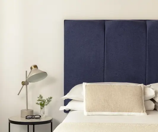 a bed with a blue headboard