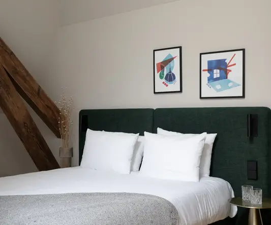 a bed with white pillows and a green headboard