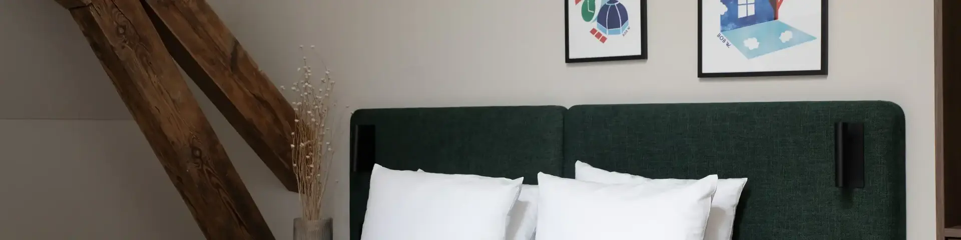 a bed with white pillows and a green headboard