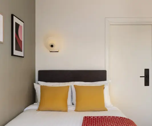 a bed with pillows and a red blanket