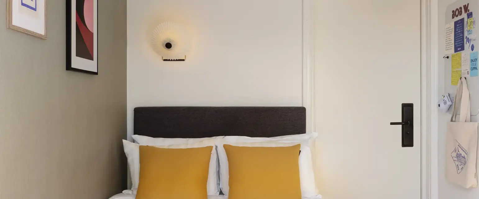 a bed with pillows and a red blanket