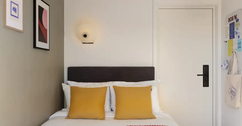 a bed with pillows and a red blanket