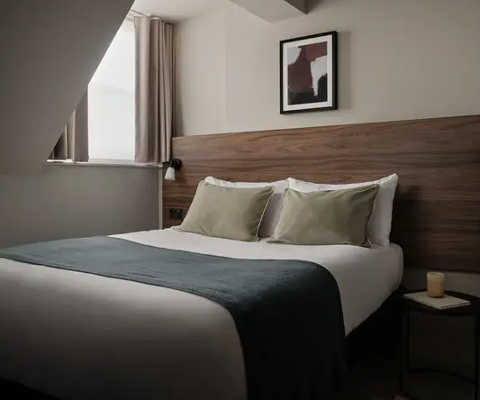 a bed with a wood headboard and a picture on the wall
