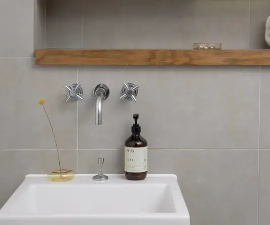a sink with a bottle and faucet