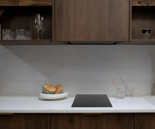 a kitchen counter with a plate of fruit and two straws