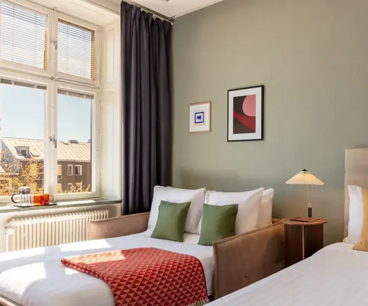 a room with two beds and a lamp