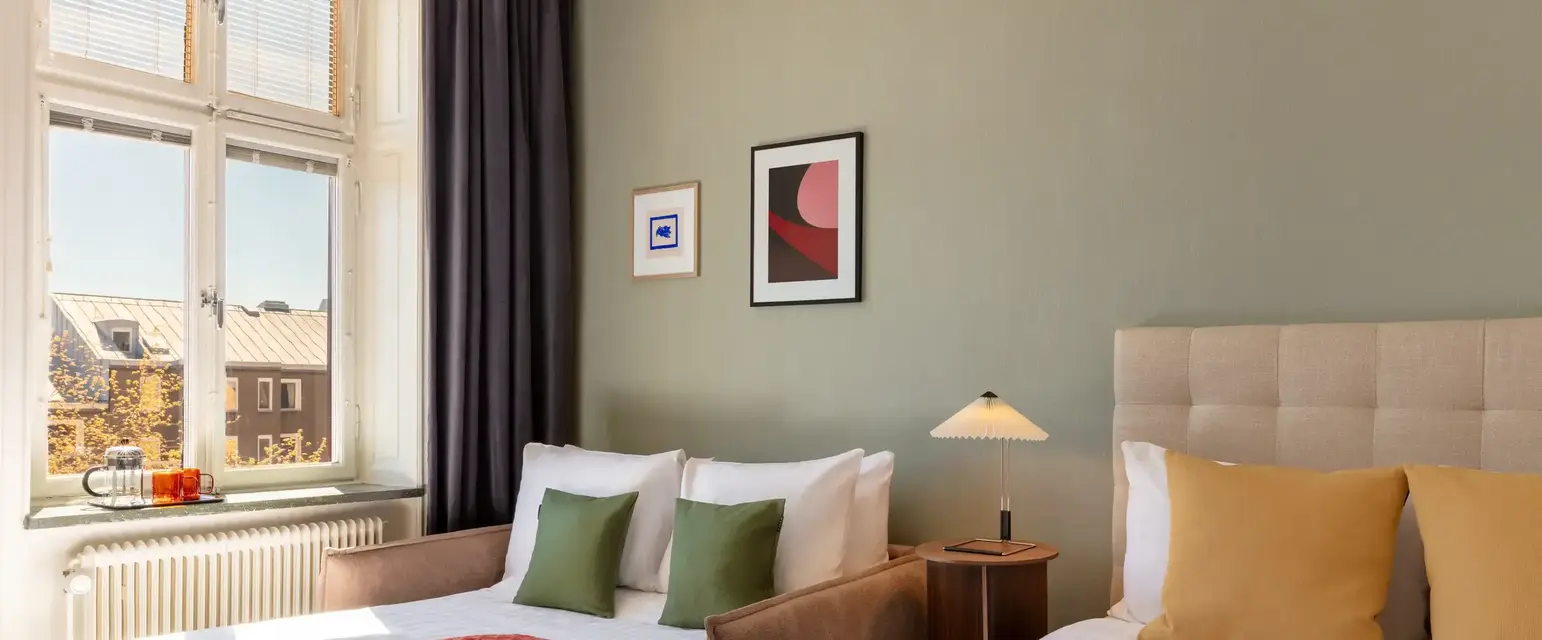 a room with two beds and a lamp