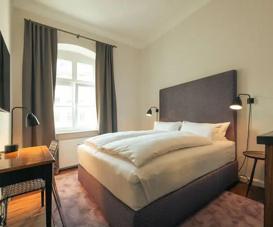 a bed with a desk and lamp