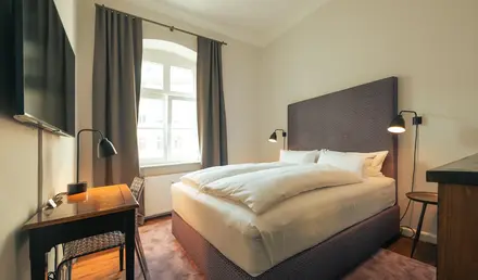 a bed with a desk and lamp