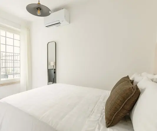 a bed with a pillow and a mirror in a room