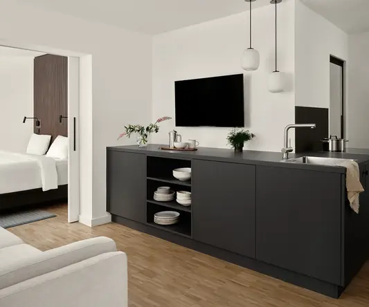 a room with a tv and a kitchen