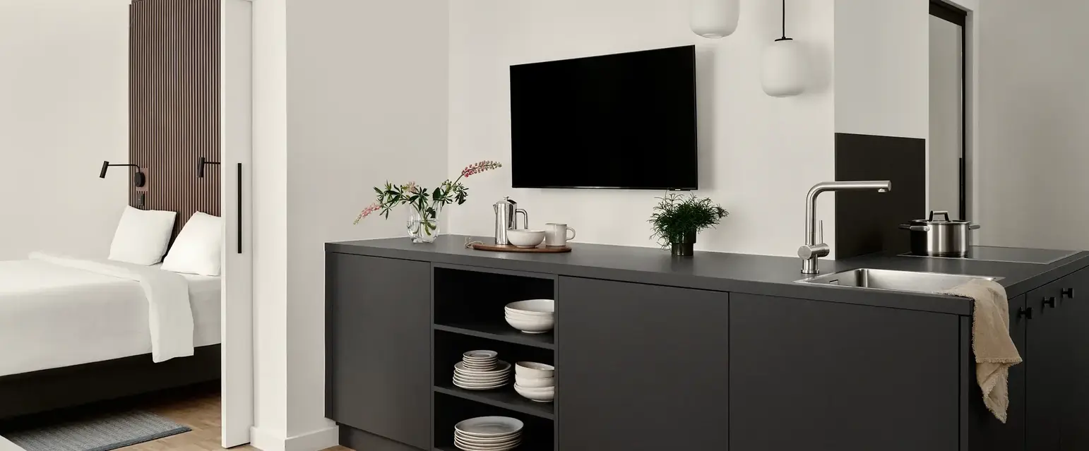 a room with a tv and a kitchen