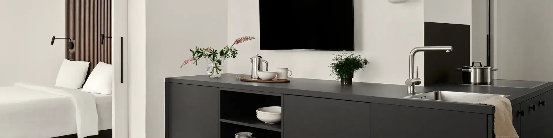 a room with a tv and a kitchen