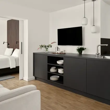 a room with a tv and a kitchen