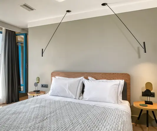 a bed with white pillows and a wood headboard