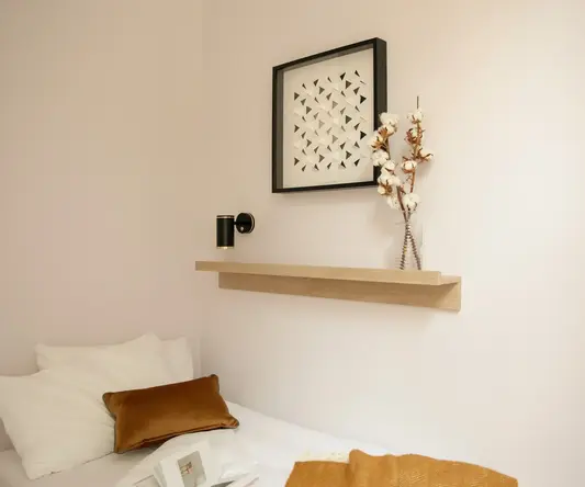 a bed with pillows and a picture on the wall