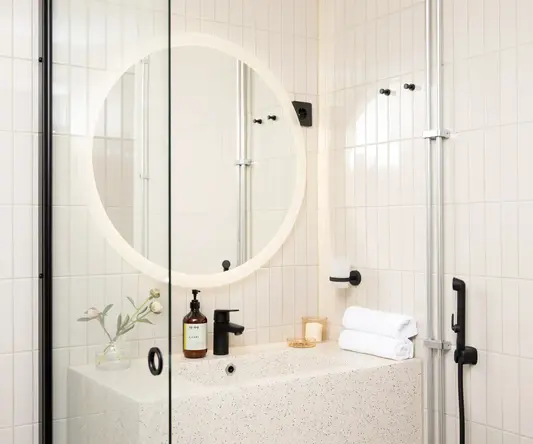 a bathroom with a round mirror