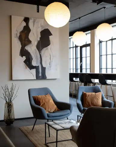 a room with chairs and a painting