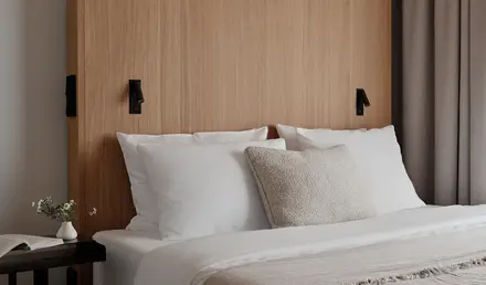 a bed with white pillows and a wood headboard