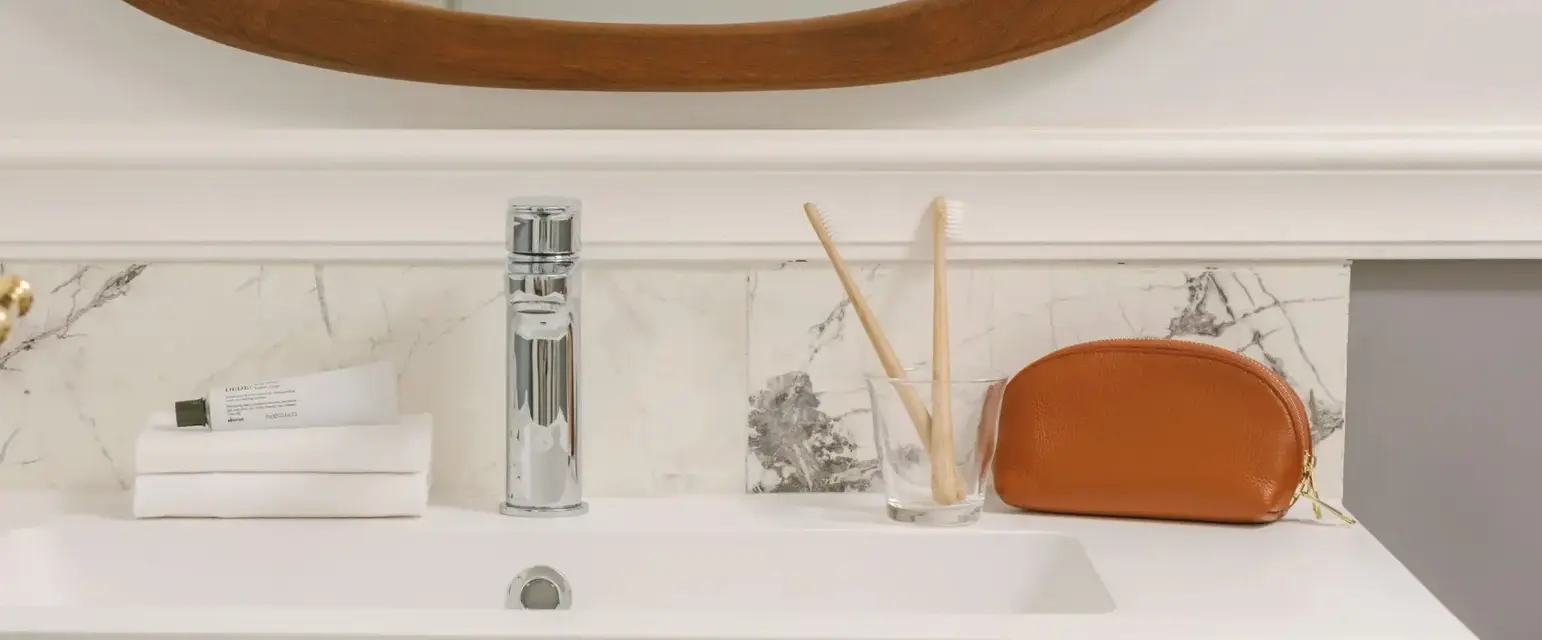 a bathroom sink with a mirror and a glass