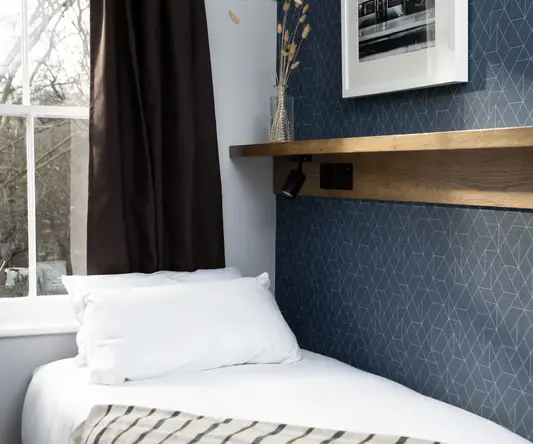 a bed with pillows and a shelf in a room