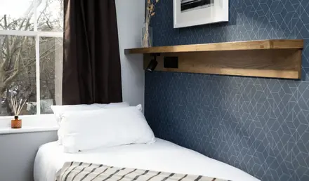a bed with pillows and a shelf in a room
