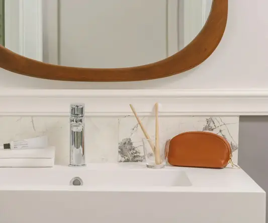 a bathroom sink with a mirror and a glass