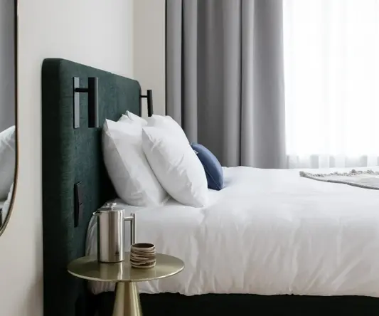 a bed with white sheets and pillows