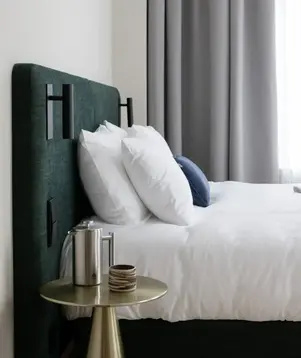 a bed with white sheets and pillows