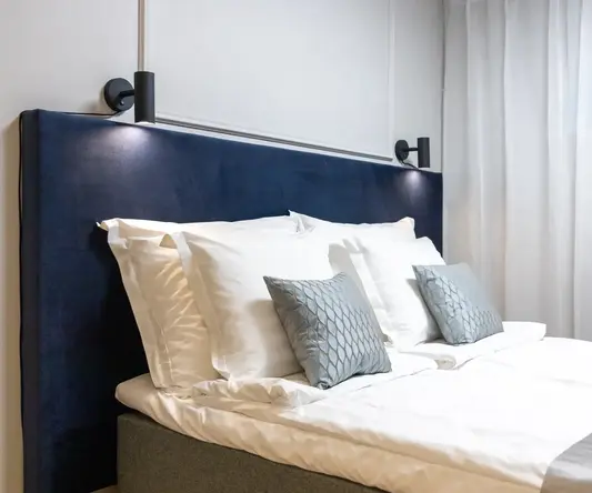 a bed with pillows and a blue headboard
