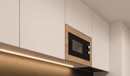 a kitchen with white cabinets and black countertops