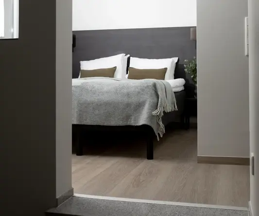 a bed with pillows and a plant in the middle